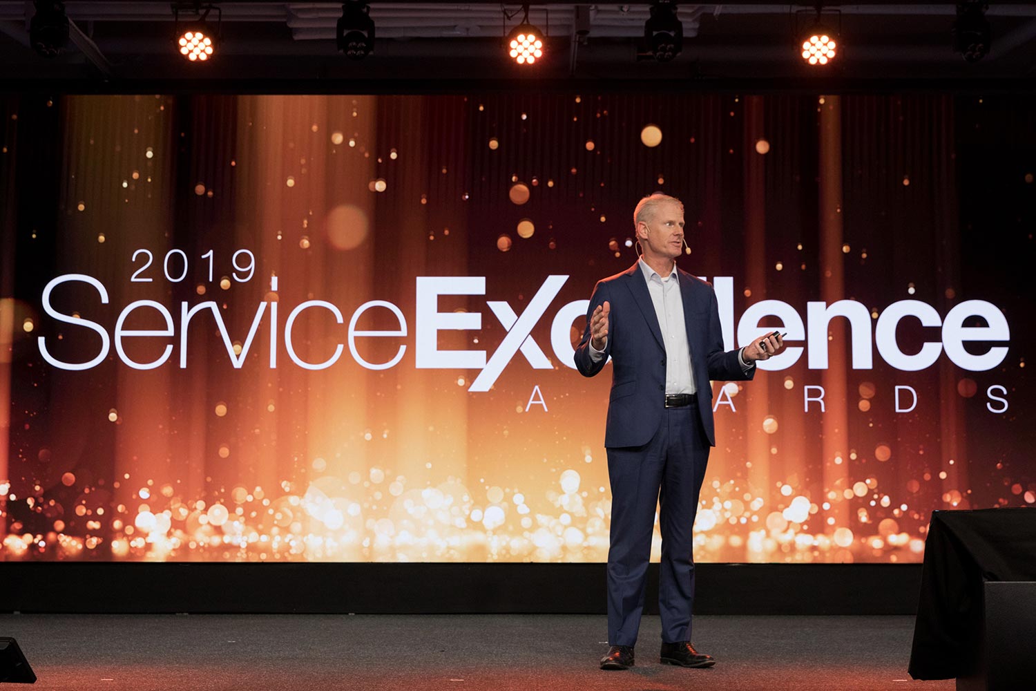 man standing on a stage at 2019 service excellence awards