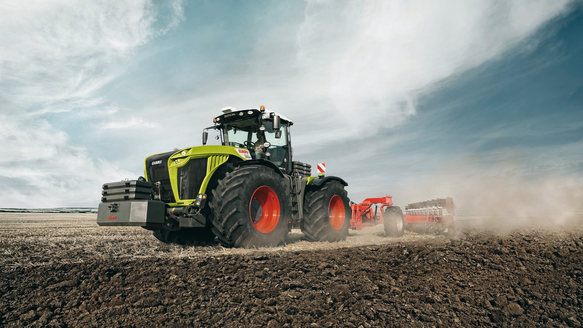 green tractor plowing fields