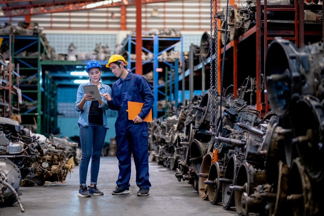 2 workers in a warehouse looking at a tablet