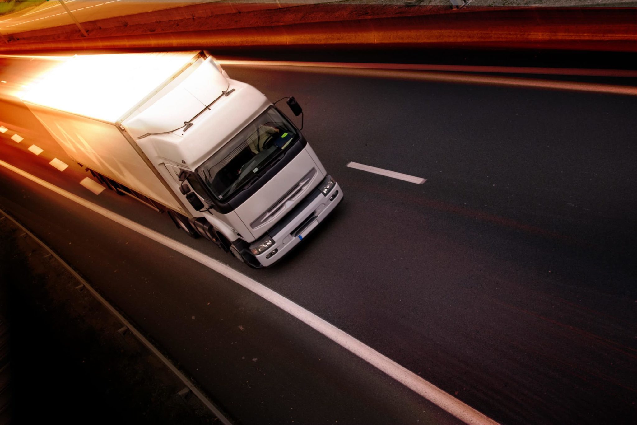 white semi truck driving down a road