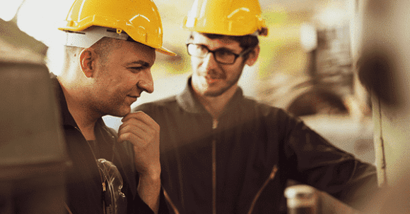 Two technicians standing with hardhats