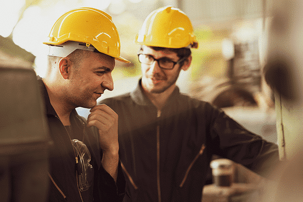 Two technicians standing with hardhats