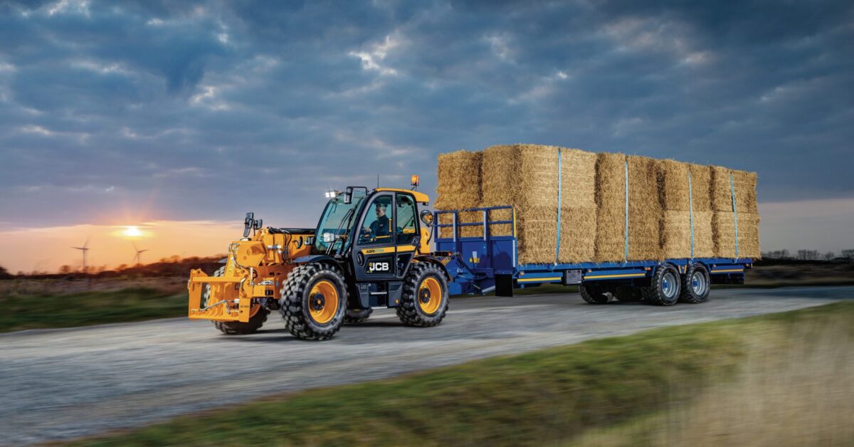 JCB equipment pulling trailor of hay