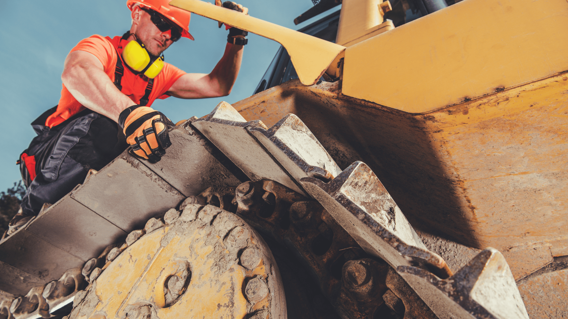 Technician working on track of construction equipment