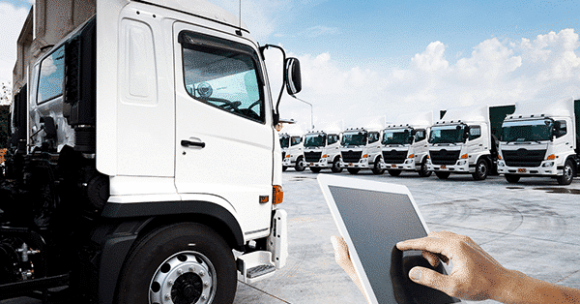 Holding tablet in front of parked PACCAR trucks