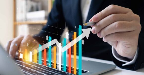 Virtual bar chart with arrow up. Man in background with pen pointing at it